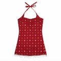 A red halter-neck top with a small repeating gold and white pattern, featuring white tassel fringe along the hem and tie straps, shown against a plain white background.