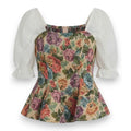 A vintage-style floral dress top featuring a peplum waist, a beige background with a colorful rose and floral pattern, and contrasting white puff sleeves with ruffled cuffs.
