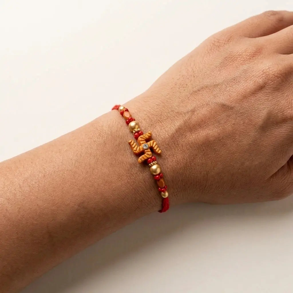 Traditional Swastika Rakhi with Red & Gold Beads